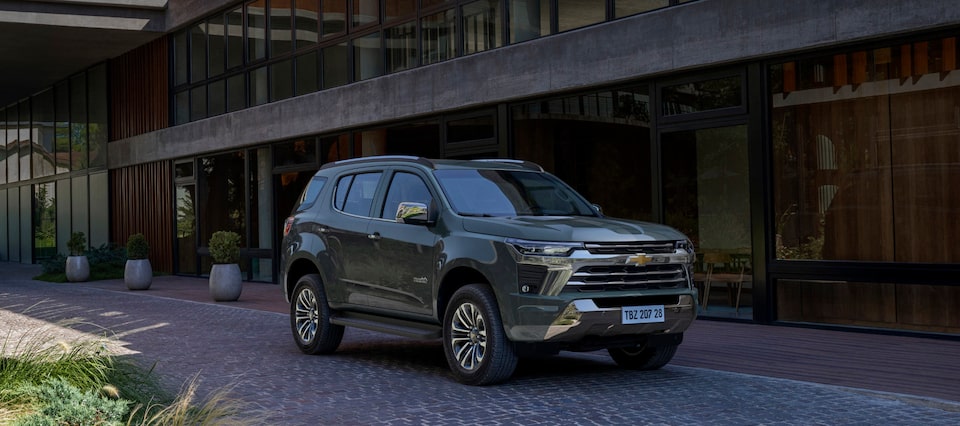 Imagem do novo SUV Chevrolet Trailblazer High Country, cinza topázio, estacionado em frente a uma casa.