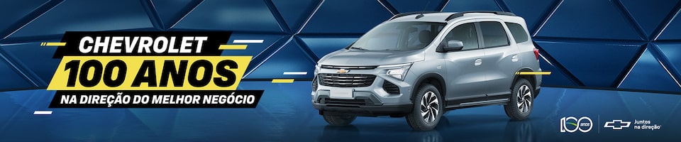 Um Chevrolet SUV prateado é exibido contra um fundo geométrico azul. O texto diz: Chevrolet 100 anos na direção do melhor negócio. Os logotipos incluem 100 anos e o símbolo da Chevrolet com a frase Juntos na mesma direção.