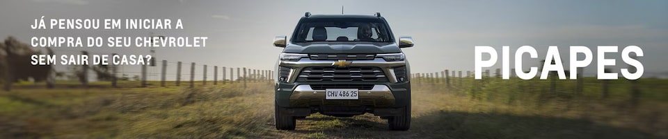 Uma caminhonete está em uma estrada rural, com uma cerca e campos gramados de cada lado. O texto à esquerda pergunta se você considerou comprar um Chevrolet de casa. A palavra PICAPES está em letras grandes à direita.