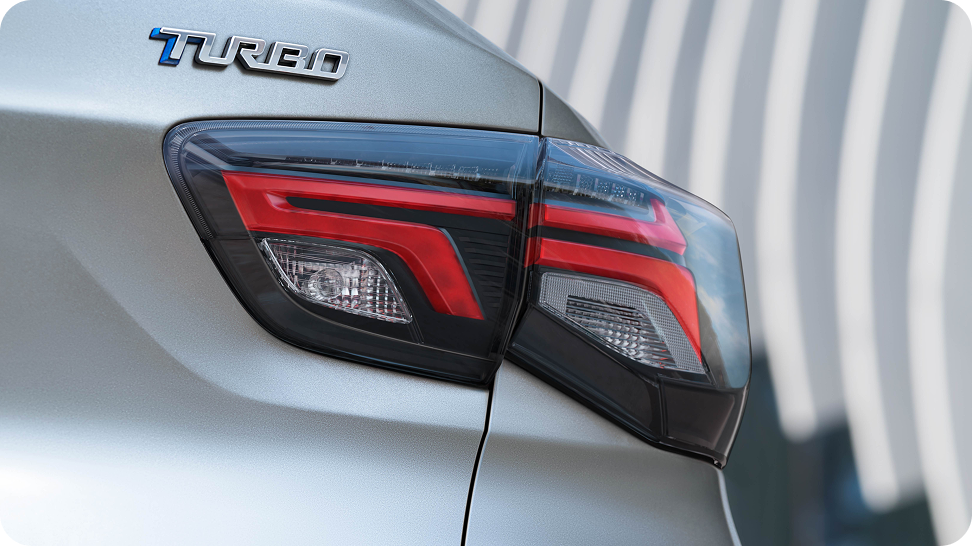 Detalhe da lanterna traseira do Chevrolet Onix com badge “Turbo” em destaque, na cor Prata Shark.