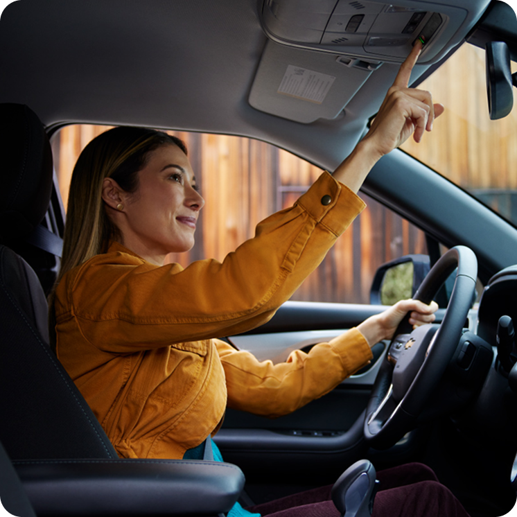 Mulher no carro apertando o botão de OnStar