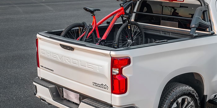 Imagem de uma bicicleta sobre o suporte de bike, dentro da caçamba da nova picape Chevrolet Silverado.